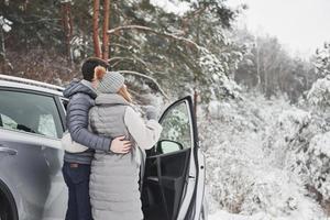 Admires beautiful nature together. Lovely couple have weekend at countryside at winter time photo