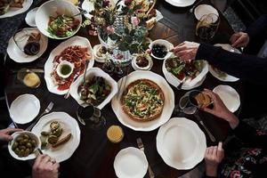 Table full of food. Family friends having nice time in beautiful luxury modern restaurant photo