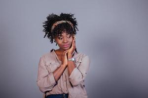 relajado y tranquilo. atractiva mujer afroamericana con ropa informal en el estudio foto