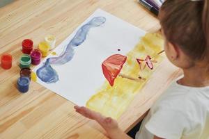 Different types of colors. Little girl is drawing by using gouache and brush. Learning in the art class photo