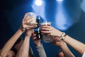 variedad de bebidas. grupo de jóvenes amigos sonriendo y haciendo un brindis en la discoteca foto