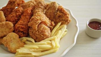 fried chicken with french fries and nuggets on plate - unhealthy food