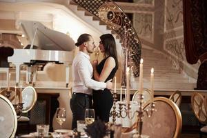 Dance time. Beautiful couple have romantic dinner in luxury restaurant at evening time photo