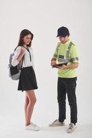 Need to check your testimony. Policeman in green uniform have conversation with young female student against white background in the studio photo