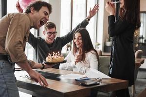 chica no lo vio venir. uno de los empleados tiene cumpleaños hoy. compañeros de trabajo amistosos decide hacer una sorpresa para ella foto