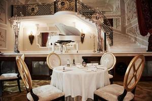 Cozy romantic atmosphere. Interior of luxury restaurant in vintage aristocratic style with piano on the stage photo