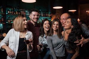 Smile for portrait. Beautiful youth have party together with alcohol in the nightclub photo