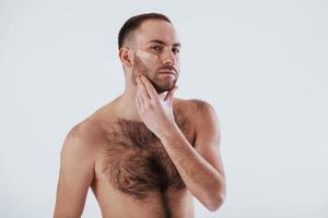 Here's what happening when you shave your beard not carefully. Man with bare chest stands against white background in the studio photo