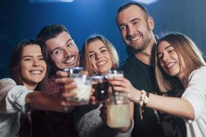 pasemos este fin de semana de la manera correcta. hermosos jóvenes tienen fiesta junto con alcohol en la discoteca foto