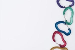 On the right side. Many of the multi colored carabiners on lying on the white table photo