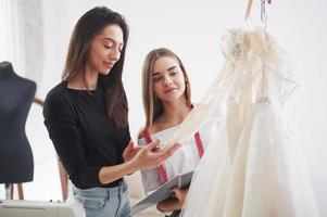 Need to check all of details to make sure that everything is perfect. The process of fitting the dress in the studio of hand crafted clothes photo