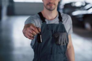 Hand of mechanic with keys. Your car is on the way again. Job well done photo