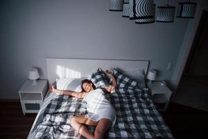 Do not disturb. Pretty young woman lying on the bed at morning time in her room photo