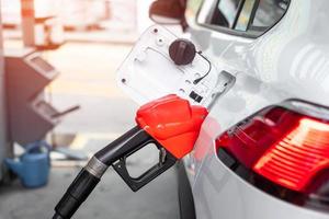 repostar en el coche, boquilla de combustible de gasolina en el vehículo en la gasolinera. precio del petróleo, economía del petróleo, inflación y concepto de productos básicos foto