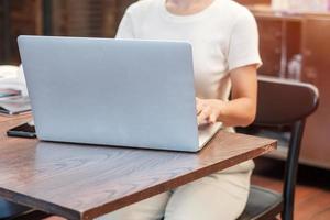 Casual Businesswoman using laptop, freelance woman typing keyboard computer notebook in cafe or modern office. technology, digital online and network concept photo