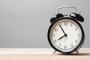 Vintage alarm clock on wooden table background and copy space for text. Activity, daily routine, morning, workout and Work life balance concept photo