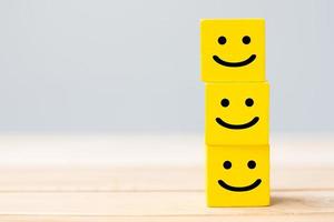 Smile face symbol on yellow wooden cube blocks. Emotion, Service rating, ranking, customer review, satisfaction and feedback concept photo