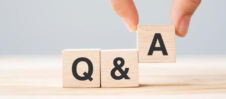 Hand holding Q and A word with wooden cube block. FAQ, Answer, Question  Ask, Information, Communication and Brainstorming Concepts photo