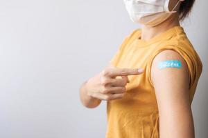 woman showing bandage after receiving covid 19 vaccine. Vaccination, herd immunity, side effect, booster dose, vaccine passport and Coronavirus pandemic photo