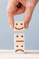 Hand holding smile face symbol on wooden cube blocks. Emotion, Service rating, ranking, customer review, satisfaction and feedback concept photo