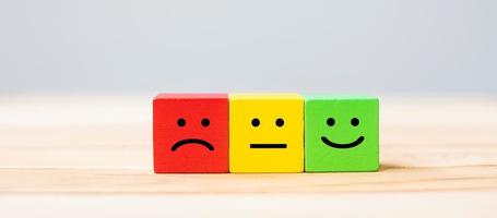 Emotion face symbol on wooden cube blocks. Service rating, ranking, customer review, satisfaction and feedback concept. photo