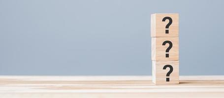 Questions Mark on wooden cube block on table background. FAQ, Answer, Q and A, Information, Communication and interrogation Concepts photo