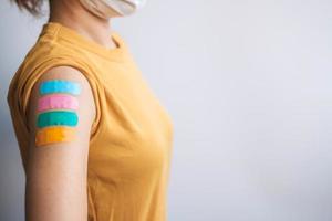 woman showing plaster after receiving covid 19 vaccine. Vaccination, herd immunity, side effect, booster dose, vaccine passport and Coronavirus pandemic photo