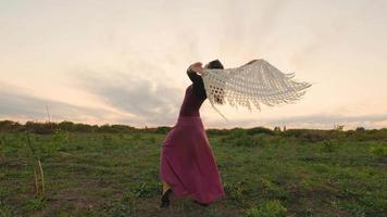 Fröhlicher weiblicher Tanz auf den Sommerfeldern bei schönem Sonnenuntergang video