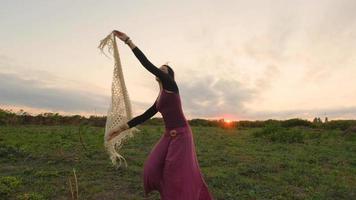 vrolijke vrouwelijke dans in de zomervelden tijdens prachtige zonsondergang video