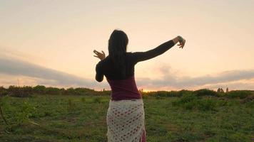 Fröhlicher weiblicher Tanz auf den Sommerfeldern bei schönem Sonnenuntergang video