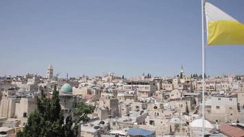 Flagge Jerusalems weht vor blauem Himmel und über der Altstadt bei Tageslicht video