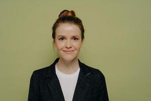 Studio portrait of smiling beautiful young woman with hair in bun photo