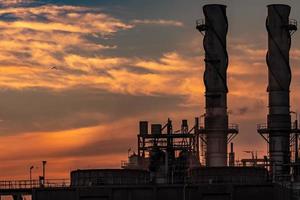Gas turbine electrical power plant. Energy for support factory in industrial estate. Natural gas tank. Small gas power plant. Power plant using natural gas for fuel. Green energy. Dramatic sunset sky. photo