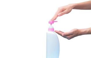 Woman hand pressed on pump cosmetic bottle isolated on white. Shampoo or hair conditioner plastic bottle and dispenser pump. Body soap or shower gel packaging. Liquid soap bottle. Body lotion bottle. photo