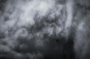 avión volando sobre cielo oscuro y nubes blancas. aerolínea comercial con concepto de destinos de ensueño. concepto de crisis empresarial de aviación. vuelo de vacaciones de viaje fallido. transporte aéreo. viaje triste. foto