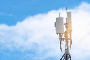 Telecommunication tower with blue sky and white clouds background. Antenna on blue sky. Radio and satellite pole. Communication technology. Telecommunication industry. Mobile or telecom 4g network. photo