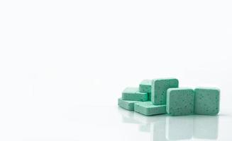 toma macro para mostrar los detalles de las pastillas médicas verdes para aliviar la tos, el dolor de garganta y la irritación de garganta sobre fondo blanco con espacio para copiar. con sabor a manzana. foto