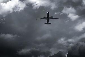 avión volando sobre cielo oscuro y nubes blancas. aerolínea comercial con concepto de destinos de ensueño. concepto de crisis empresarial de aviación. vuelo de vacaciones de viaje fallido. transporte aéreo. viaje triste. foto