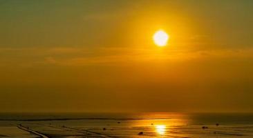 hermoso cielo al atardecer. puesta de sol en la playa. crepúsculo mar y cielo. mar tropical al atardecer. espectacular cielo naranja y dorado. mar en calma. fondo abstracto al atardecer. cielo dorado por la noche. calma y relaja la vida. foto