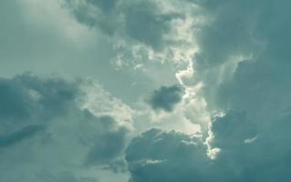 Gray sky and fluffy clouds with sunlight. Cloudy sky. Hope in darkness day. Overcast sky. Background for depressed and sad. Sad and moody sky. Nature background. Cloudscape. Sunlight behind clouds. photo