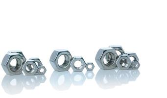 Set of metal hexagon nuts isolated on white background. Small, medium, and big of silver metal hexagon nuts. Hardware tool. Fastener with a threaded hole. Pattern of metal nuts with copy space. photo