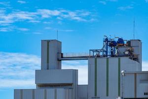 Agricultural silo at feed mill factory. Big tank for store grain in feed manufacturing. Seed stock tower for animal feed production. Commercial feed for livestock, swine and fish industries. photo