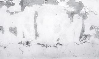 Old white concrete wall are peeling. Painted concrete wall abstract texture background. Deteriorated over time. Cracked cement wall. Empty white wall texture background for minimal life. photo