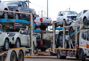 El remolque del portacoches transporta el coche nuevo desde la fábrica de fabricación hasta el distribuidor. entrega de camiones de transporte de vehículos automáticos. logística de transporte en la industria del automóvil. portacoches remolque carga coche nuevo a envio. foto