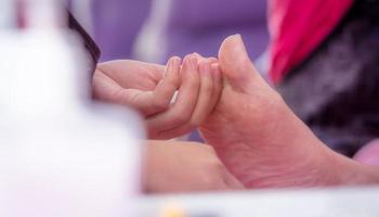 mujer que recibe servicio de pedicura de uñas de los pies por pedicurista profesional en el salón de uñas. archivo de esteticista pedicura de uñas en el salón de uñas y spa. cuidado de los pies y tratamiento de uñas en el salón de uñas. salón de belleza. foto