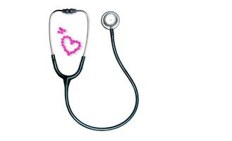 estetoscopio verde y tabletas rosadas dispuestas en forma de corazón aisladas en fondo blanco. herramienta médica de control de latidos del corazón. estetoscopio de médico de cardiología. Pastillas de warfarina en tabletas. fármacos anticoagulantes. foto