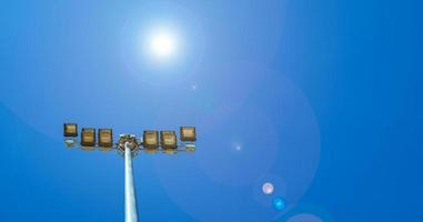 Sport lights of the stadium on beautiful blue sky with flare light. Copy space photo