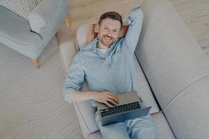 Happy young freelancer relaxing after finishing commission photo