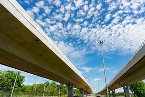 Bottom view of elevated concrete highway. Overpass concrete road. Strong structure of cement bridge. Concrete bridge engineering construction. Bridge architecture. Infrastructure budget policy concept photo