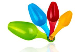 Set of colorful plastic measuring spoon isolated on white background with shadow. Green, blue, red, and orange plastic measuring spoon. photo